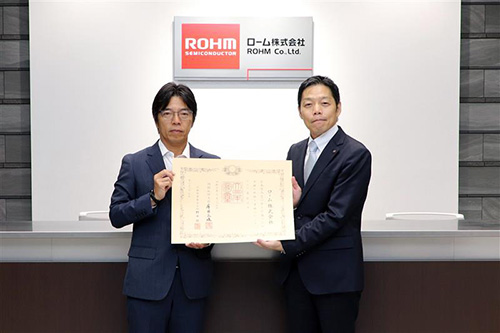 The Conveyance Ceremony of the Medal with Dark Blue Ribbon from the City of Kyoto Kotaro Tanaka, Director for Global Environment and Energy, Environmental Policy Bureau, City of Kyoto（Right） Koji Yamamoto, Member of the Board, Senior Corporate Officer, CSO, ROHM Co., Ltd.（Left）